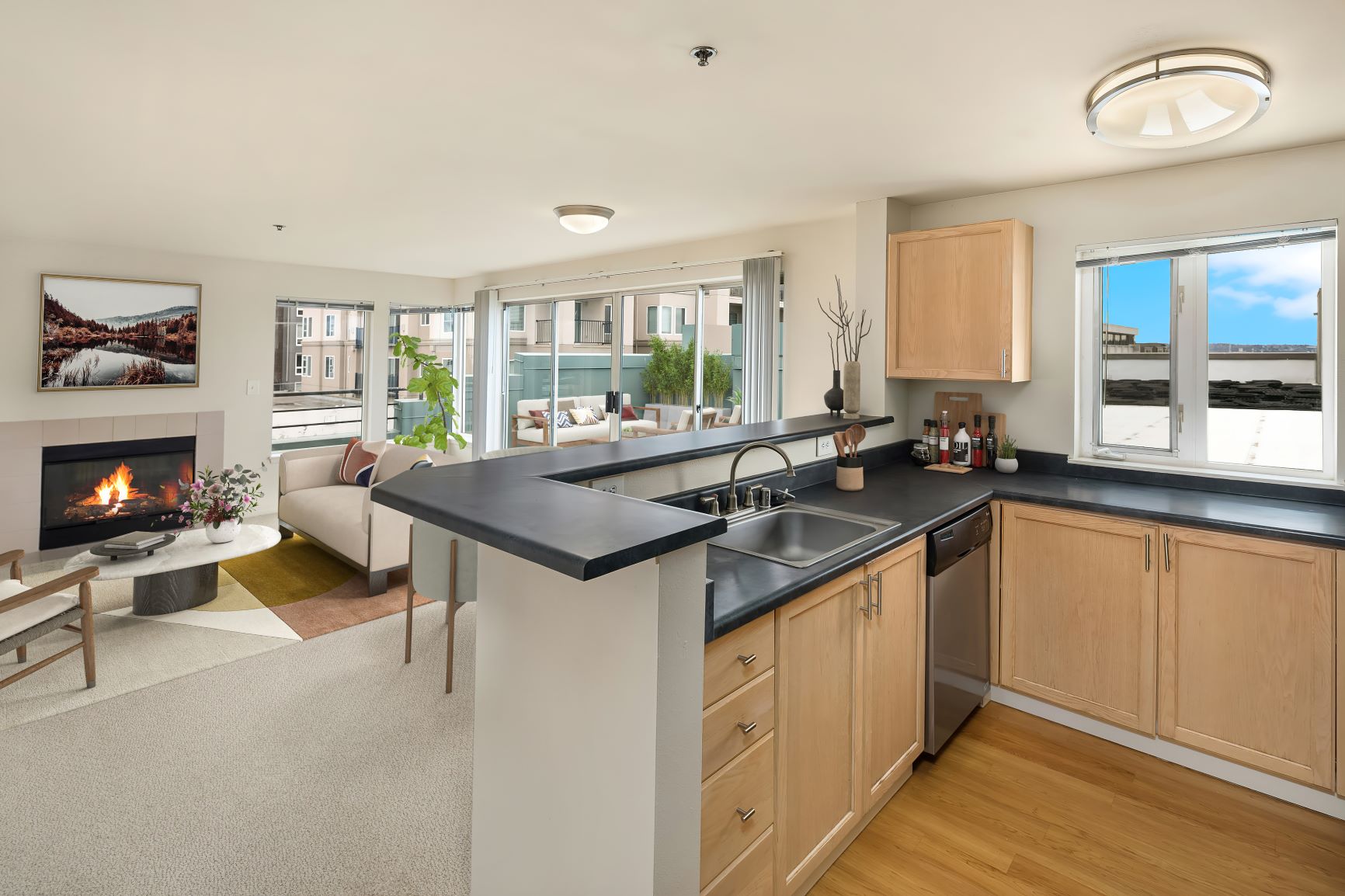 Stainless steel appliances and sleek countertops in an open-concept kitchen and living room