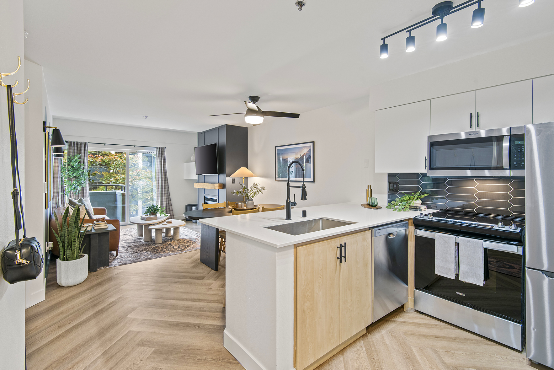 A modern kitchen with stainless steel appliances, including a refrigerator, stove, dishwasher, and microwave. The kitchen also has a stainless steel sink and granite countertops.