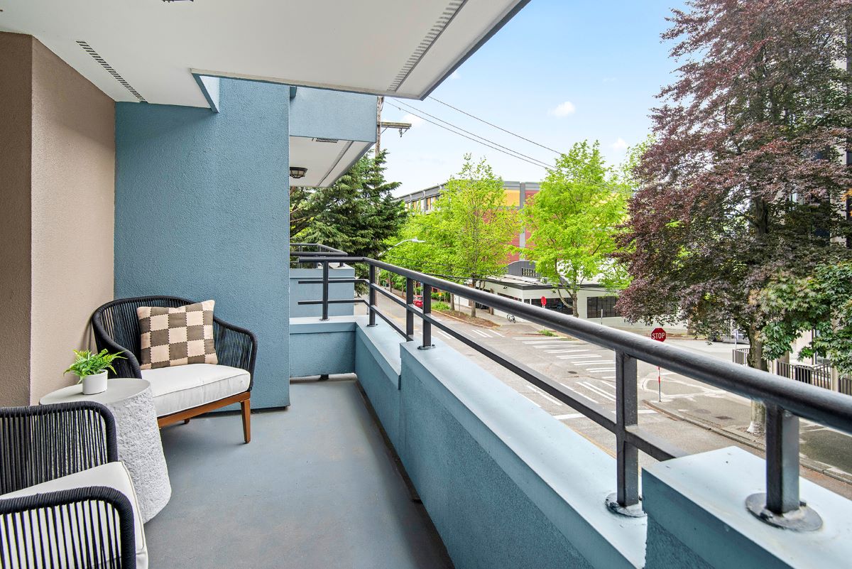 A private balcony in an apartment with a table and two chairs overlooking Queen Anne.